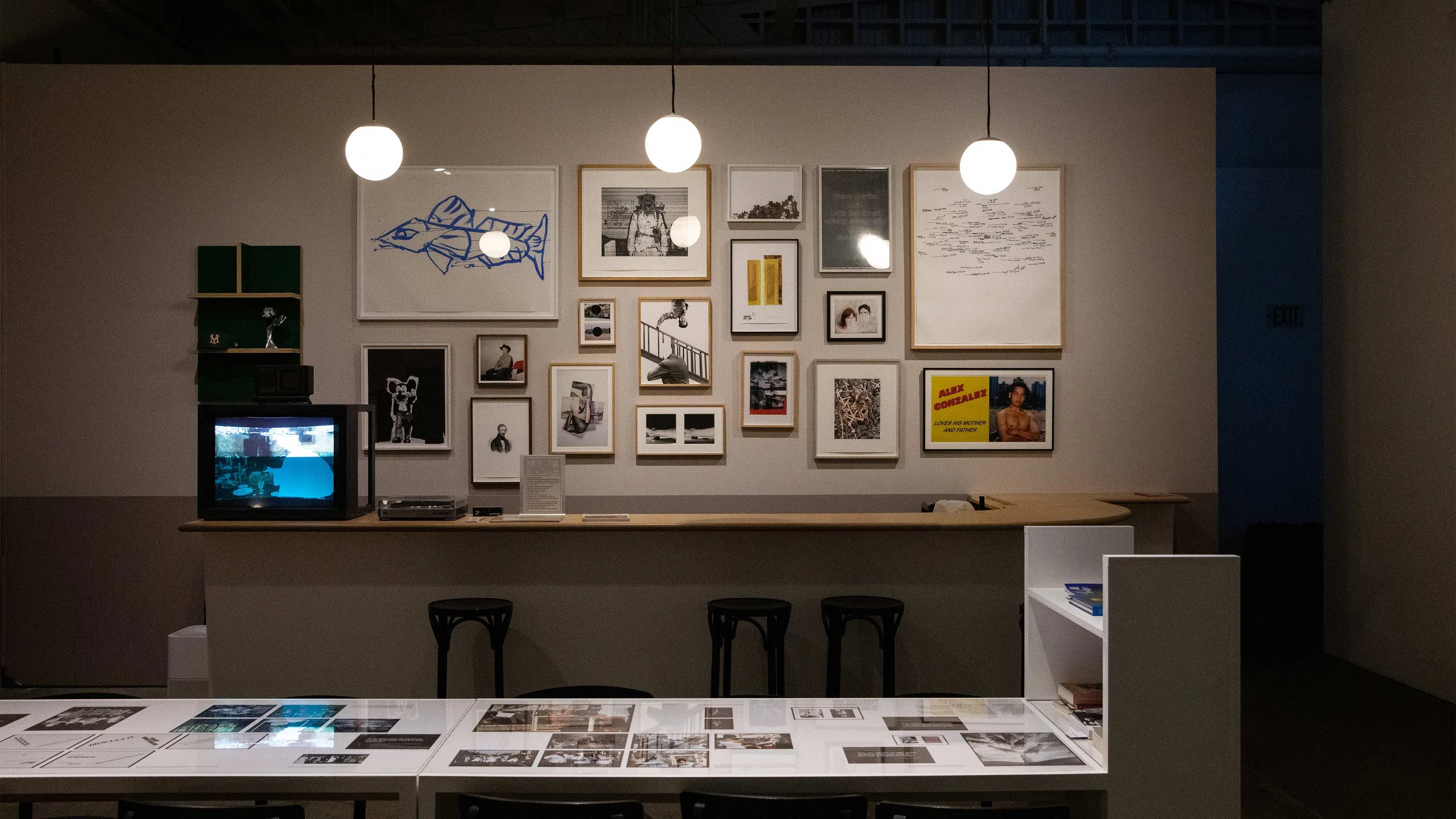 The bar/library at the Wattis has a gallery wall, bar, bar stools, and long table.