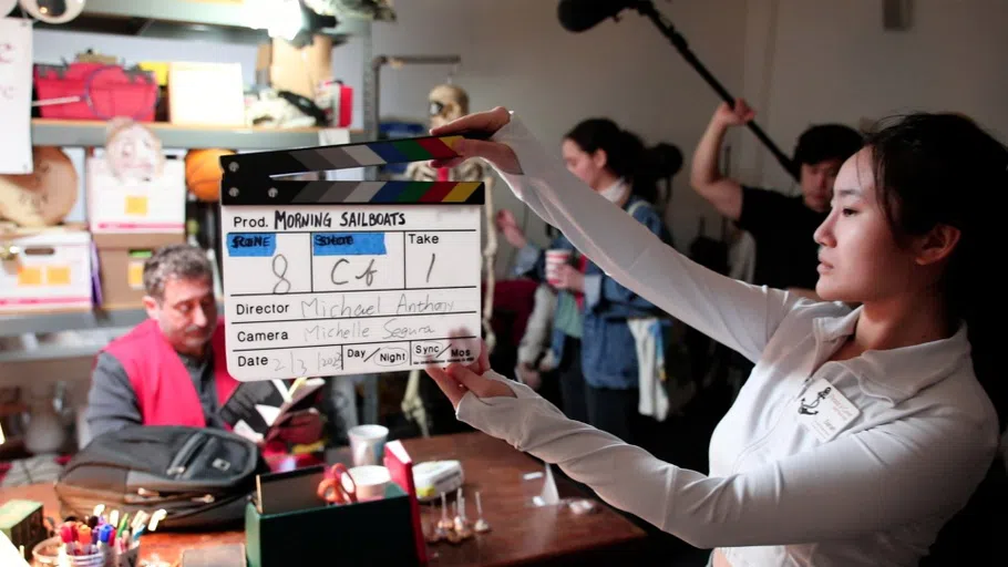 A student holds up a clapboard. 