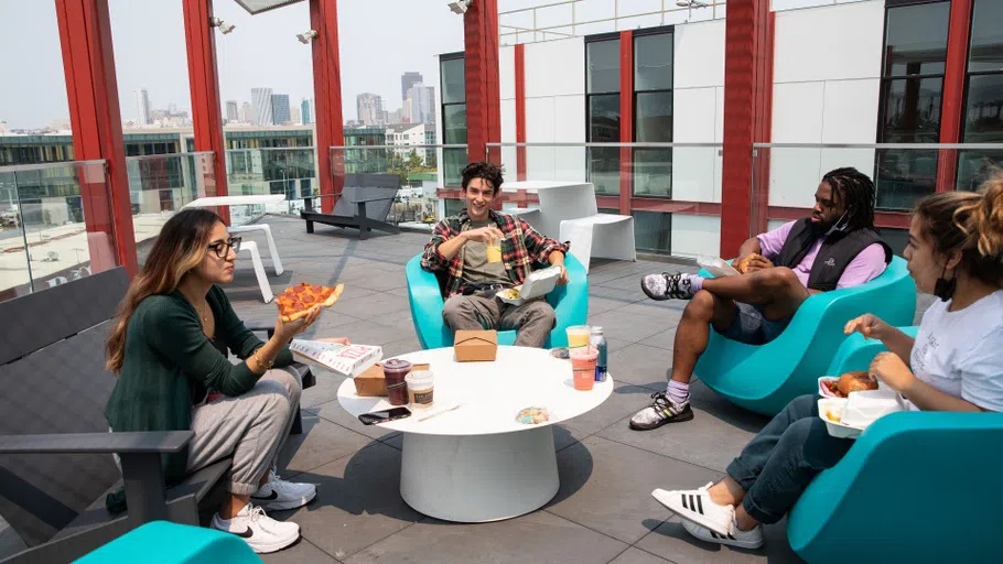 tudents eat pizza on the Founders Hall terrace.