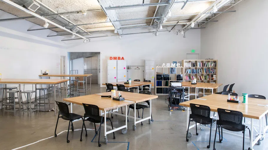 A room filled with tables, chairs and bookshelves.