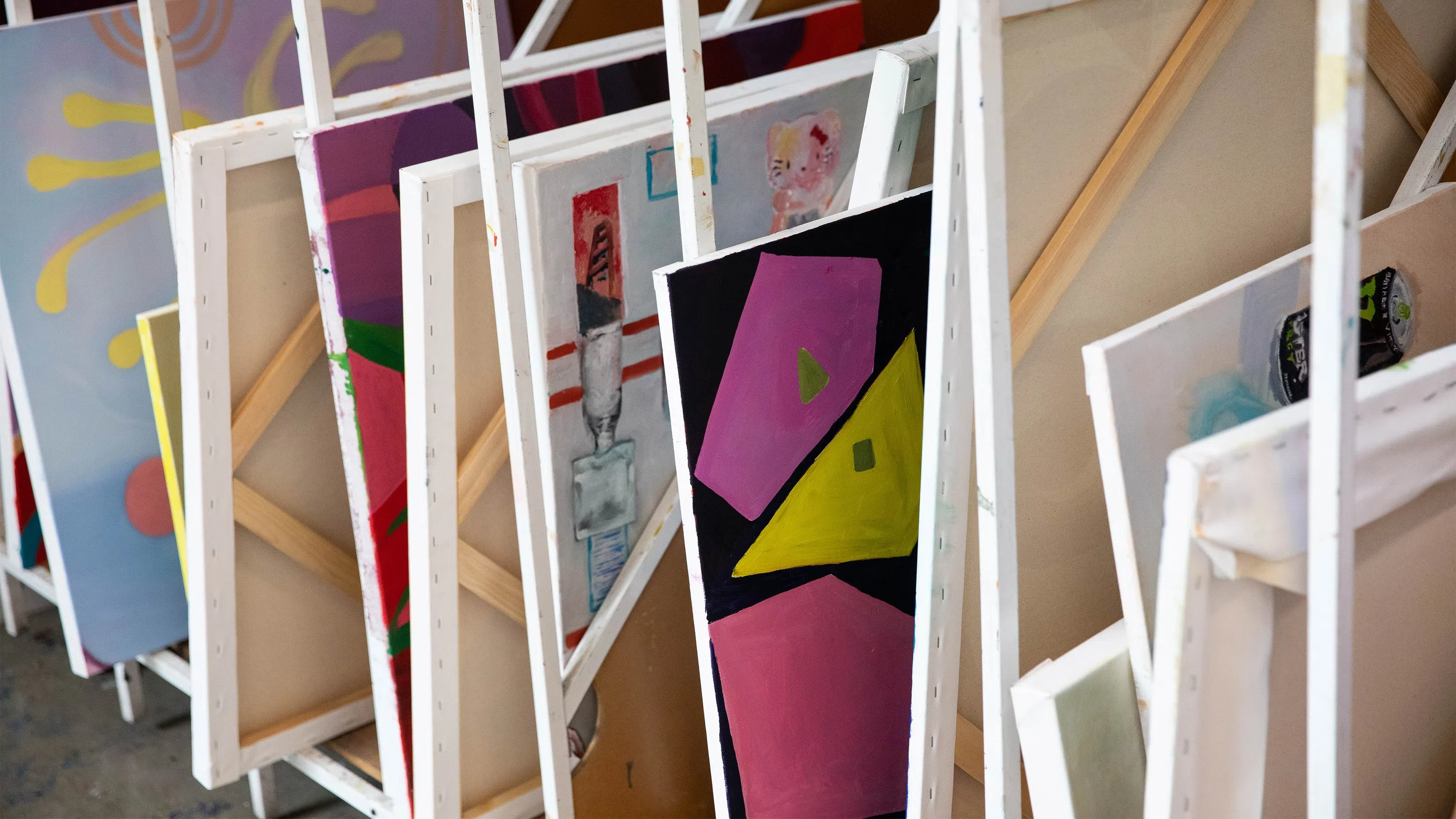 Various paintings dry in painting racks.