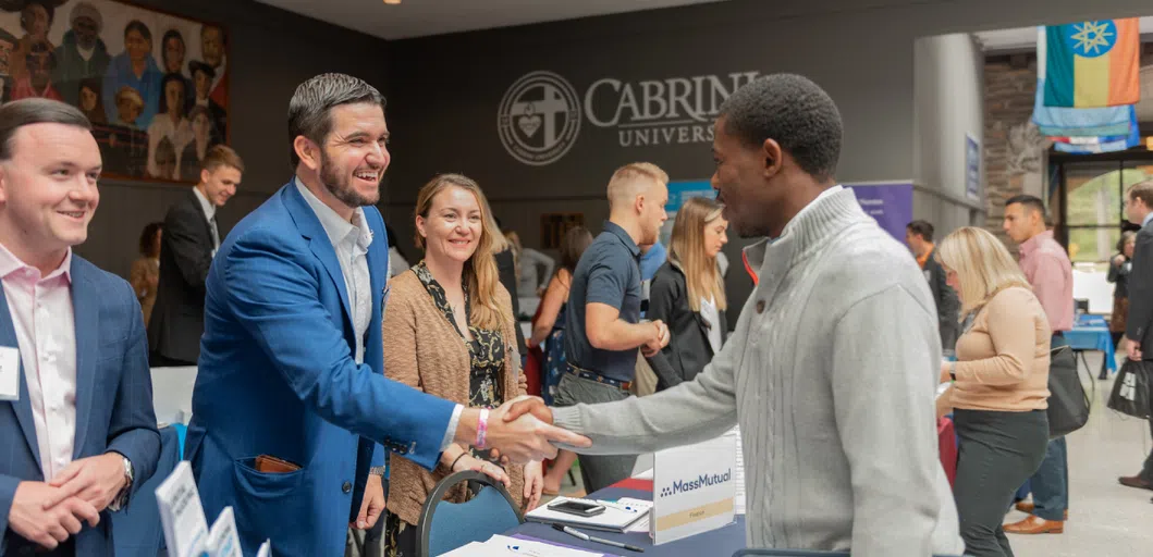 Cabrini student shakes hands with an employee at the career fair