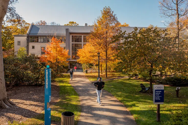 Students walking out building down a path