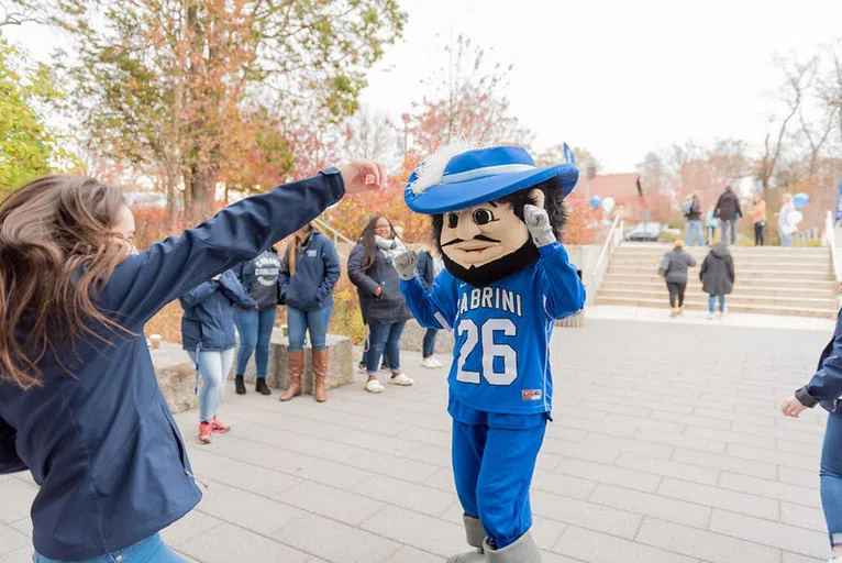 Calvin the Cavalier cheers on a student as he walks into the rec center.