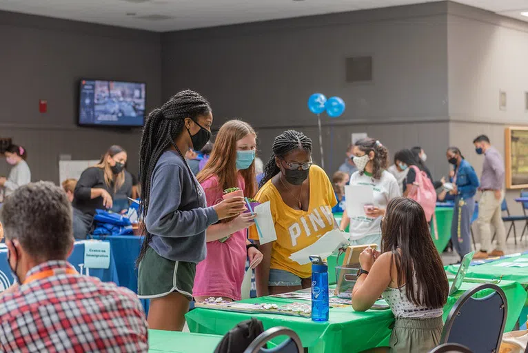 Picture of a group of student learning about the clubs and activities at the University