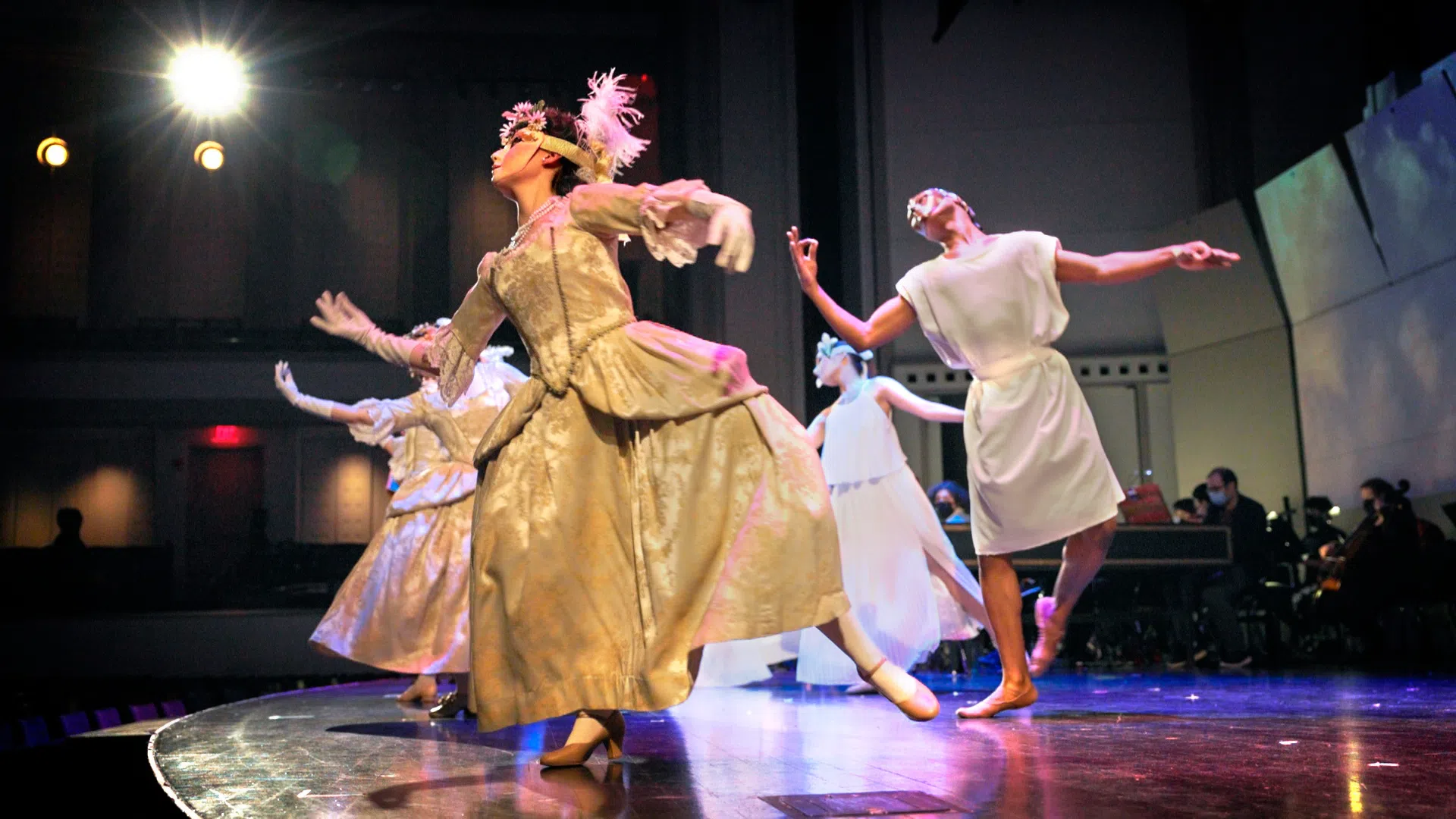 A dance troupe, clad in flowing robes, performs in Bailey Hall.