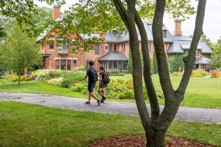 Students walk along a path through the garden behind the A.D. White House. 