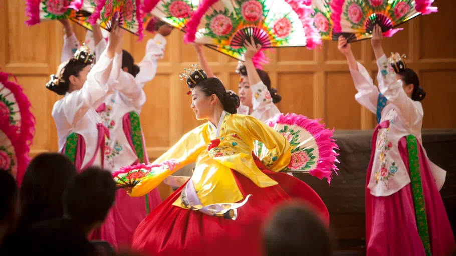 Dancers wearing traditional Chinese dress perform a dance.