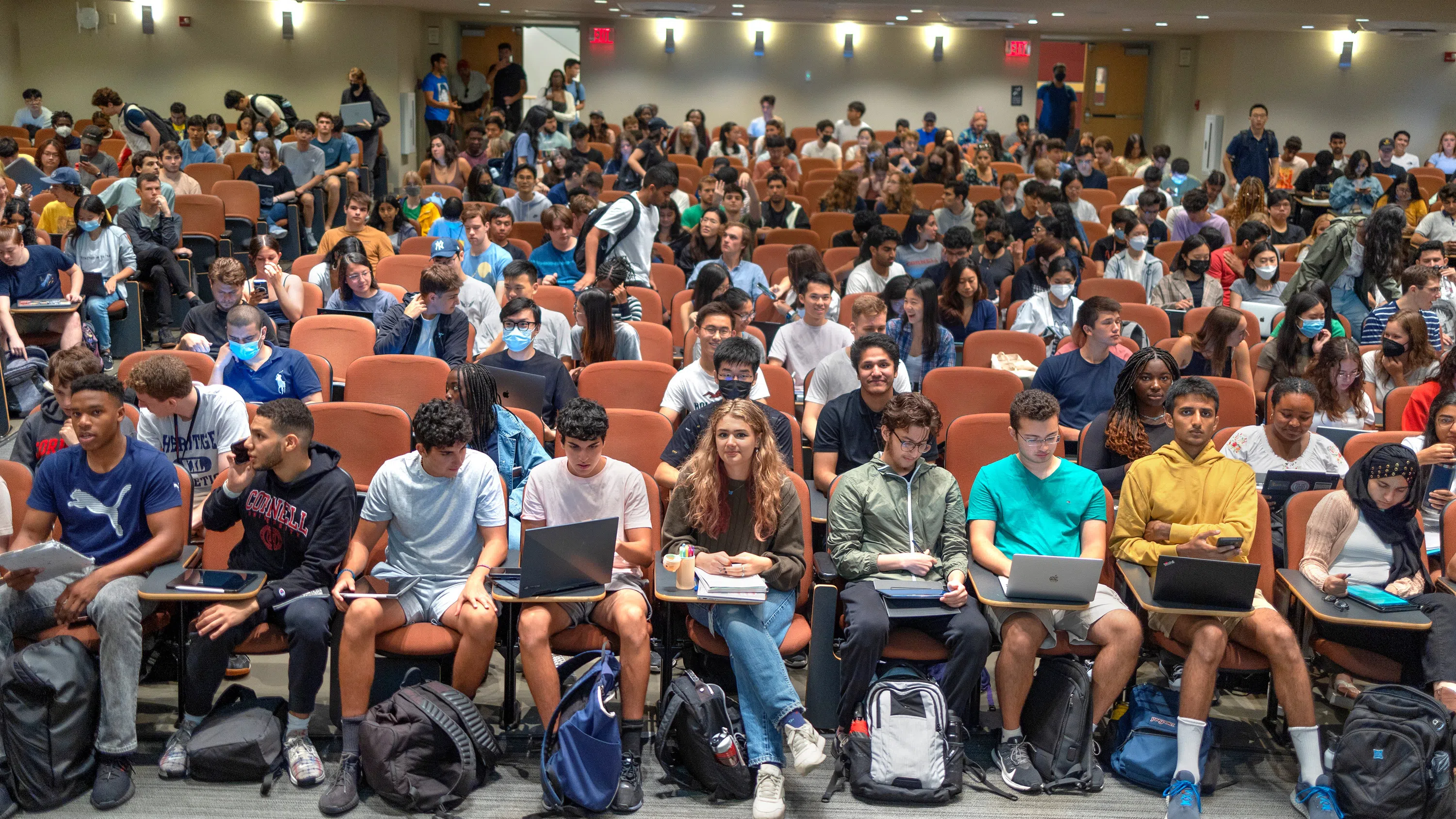 The photo, taken from the front of a lecture hall, shows more than a hundred students gathering for a class.