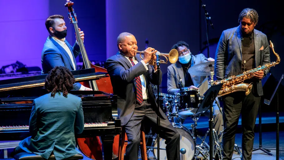 Jazz trumpeter Wynton Marsalis plays on the stage at Bailey Hall. Surrounding him, clockwise from left, are musicians playing piano, upright bass, drums, and saxophone.