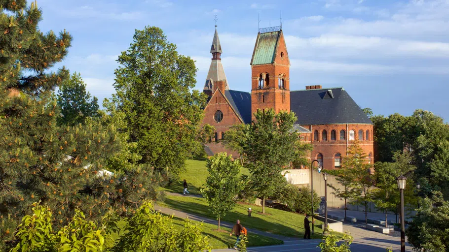 The exterior of Barnes Hall, a red brick building situated on Ho Plaza surrounded by trees.