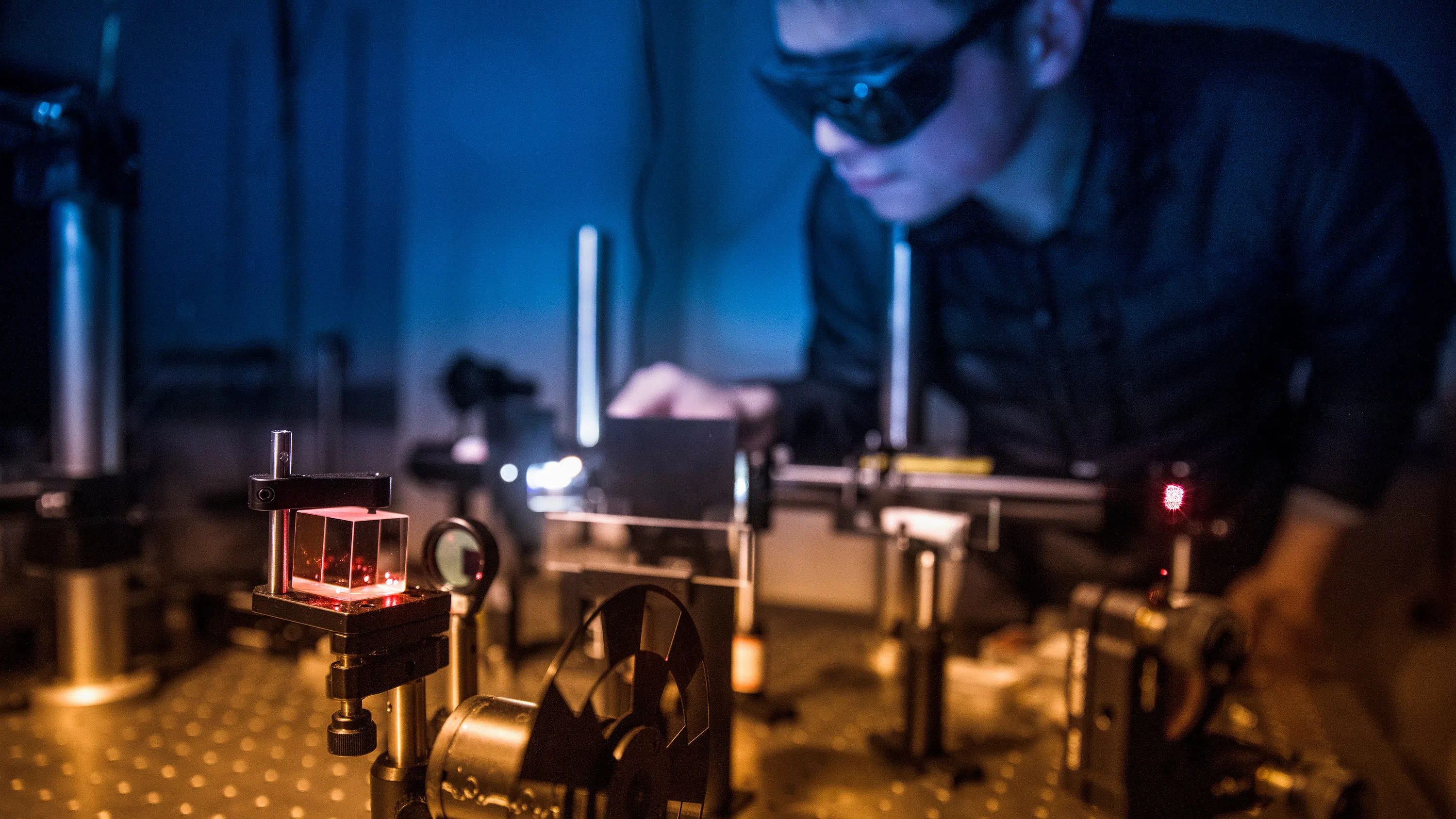 A student wearing safety goggles performs an experiment in one of the Physical Science Building's labs for applies and engineering physics.