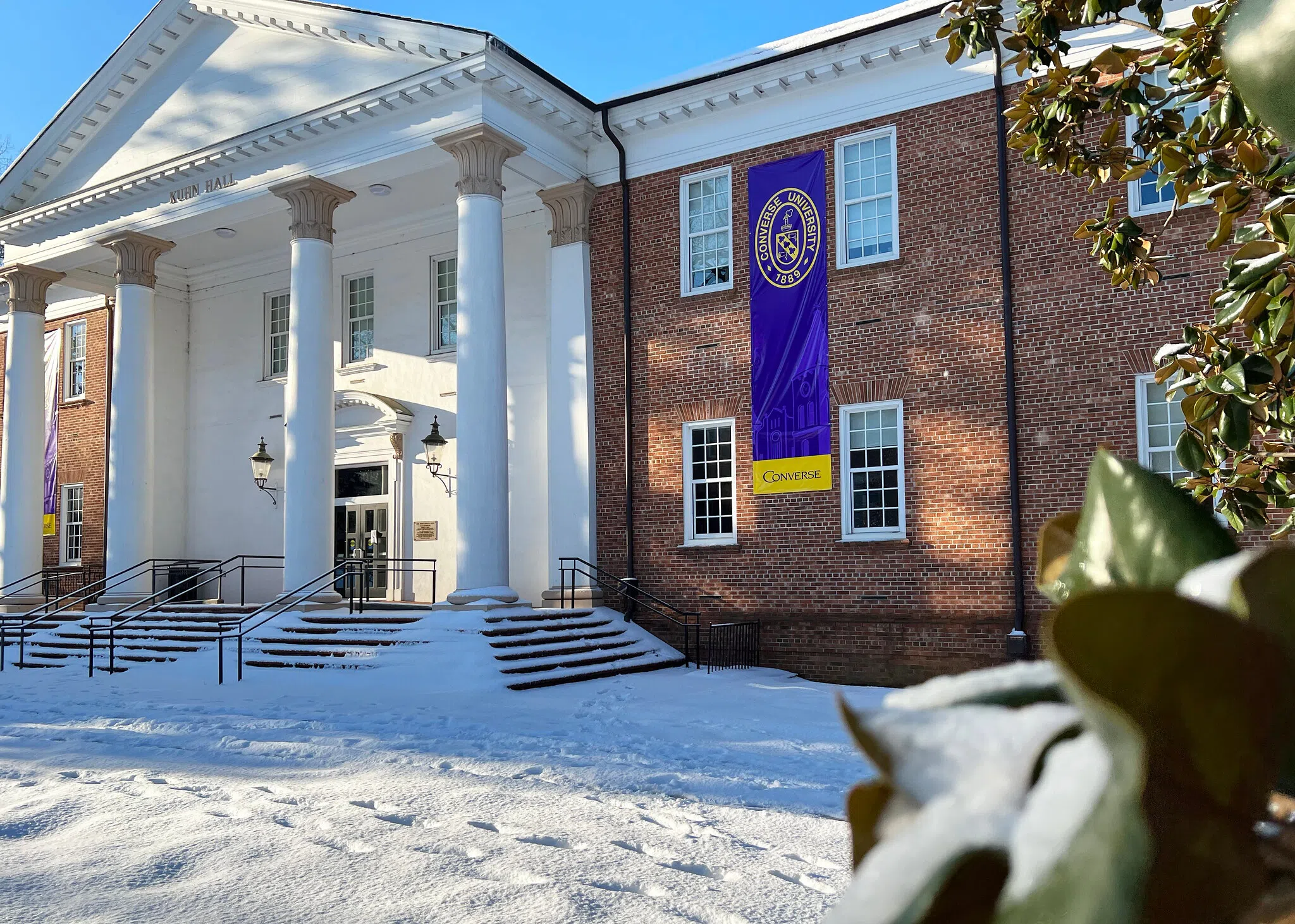 Slightly offset view of two story brick building with four-column white portico.