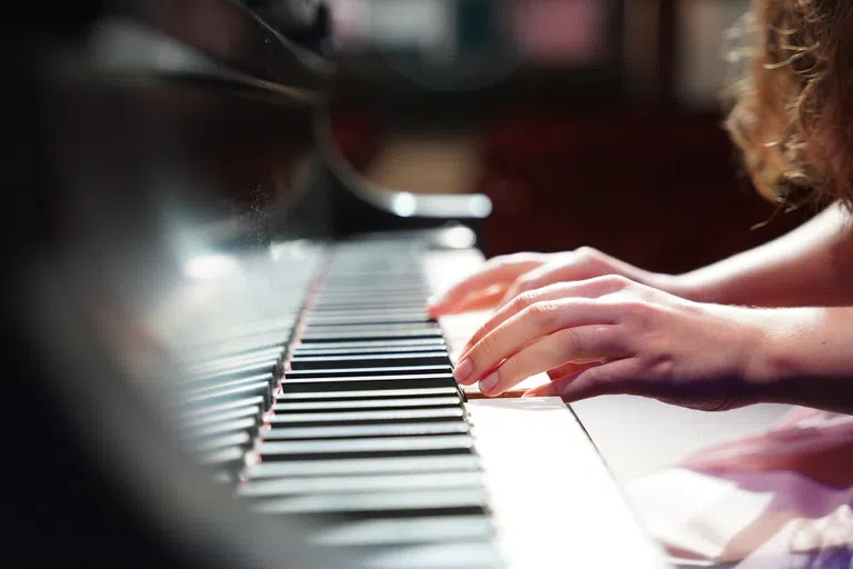 Close up image of two hands playing piano keys.