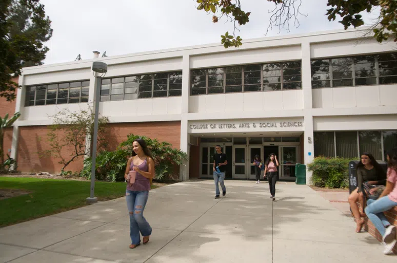 students walking in front of the College of Letters, Arts and Social Sciences building