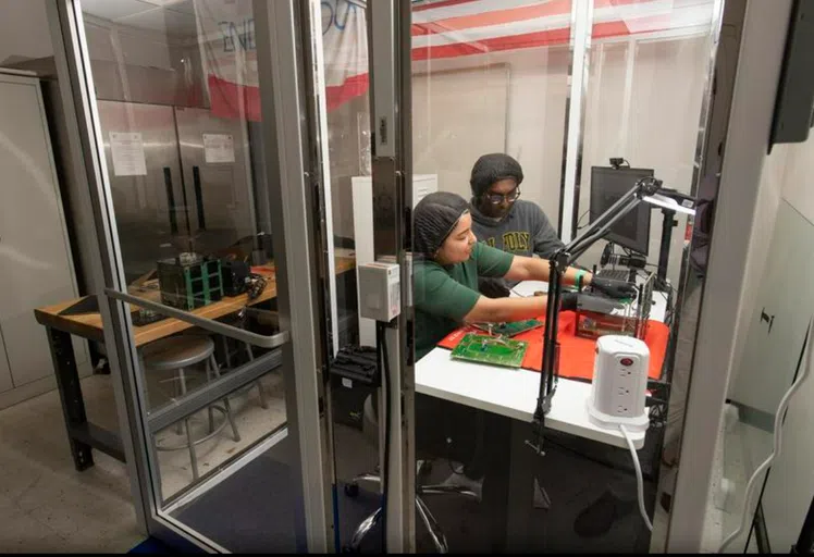 Two students working on computer motherboards