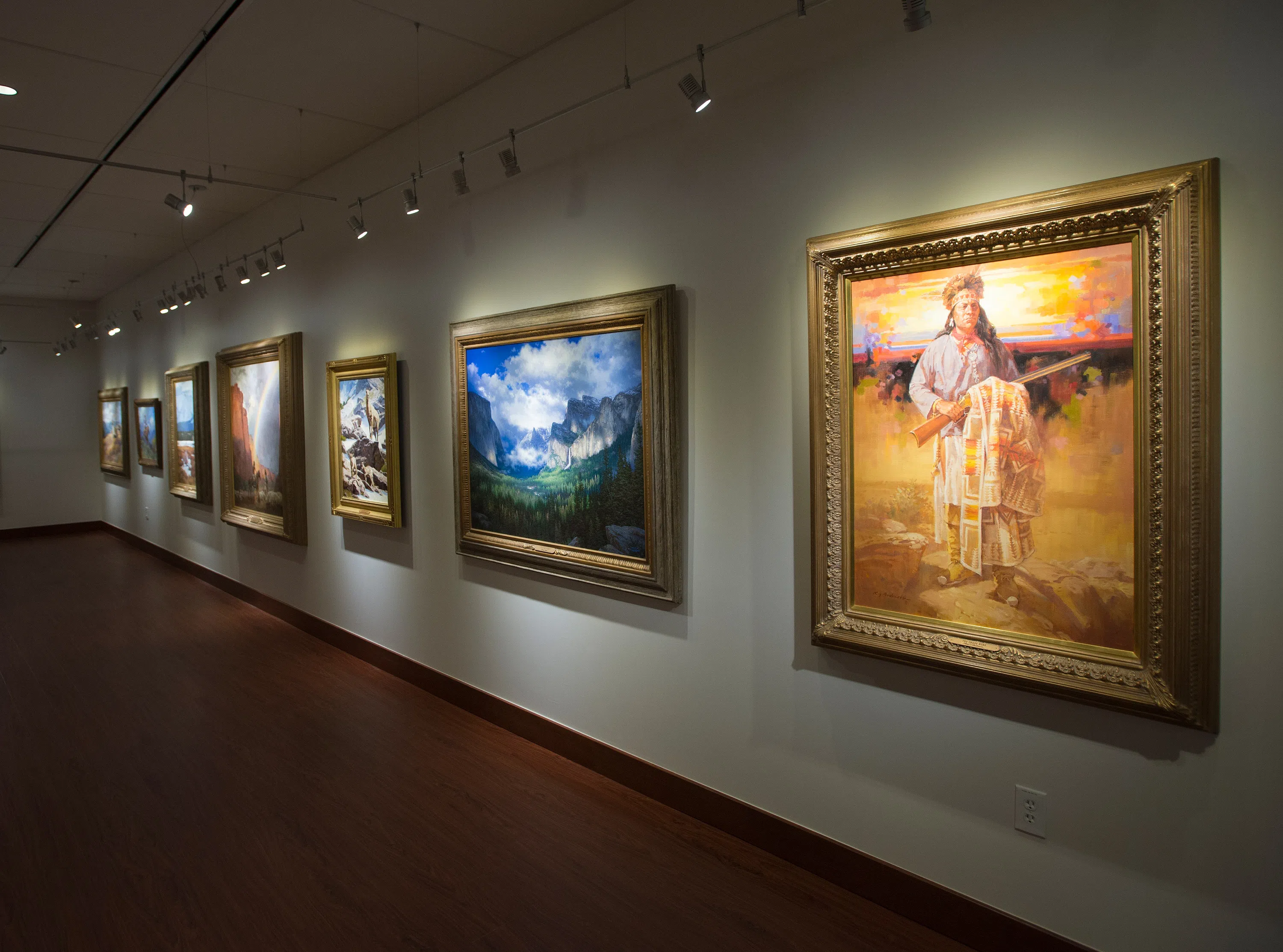 A wall of framed artwork in the Huntley art gallery