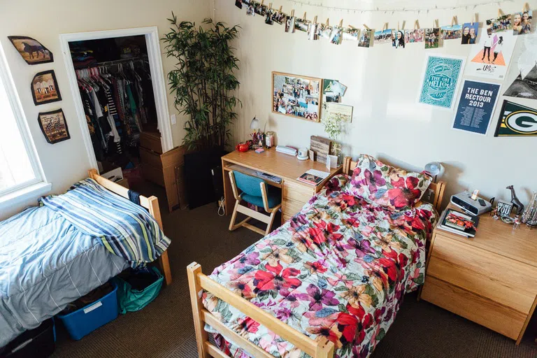 Apartment bedroom with two double beds, a desk, a dresser and wall decor