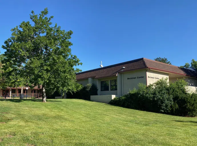 green grass and tree with white building and brown roof