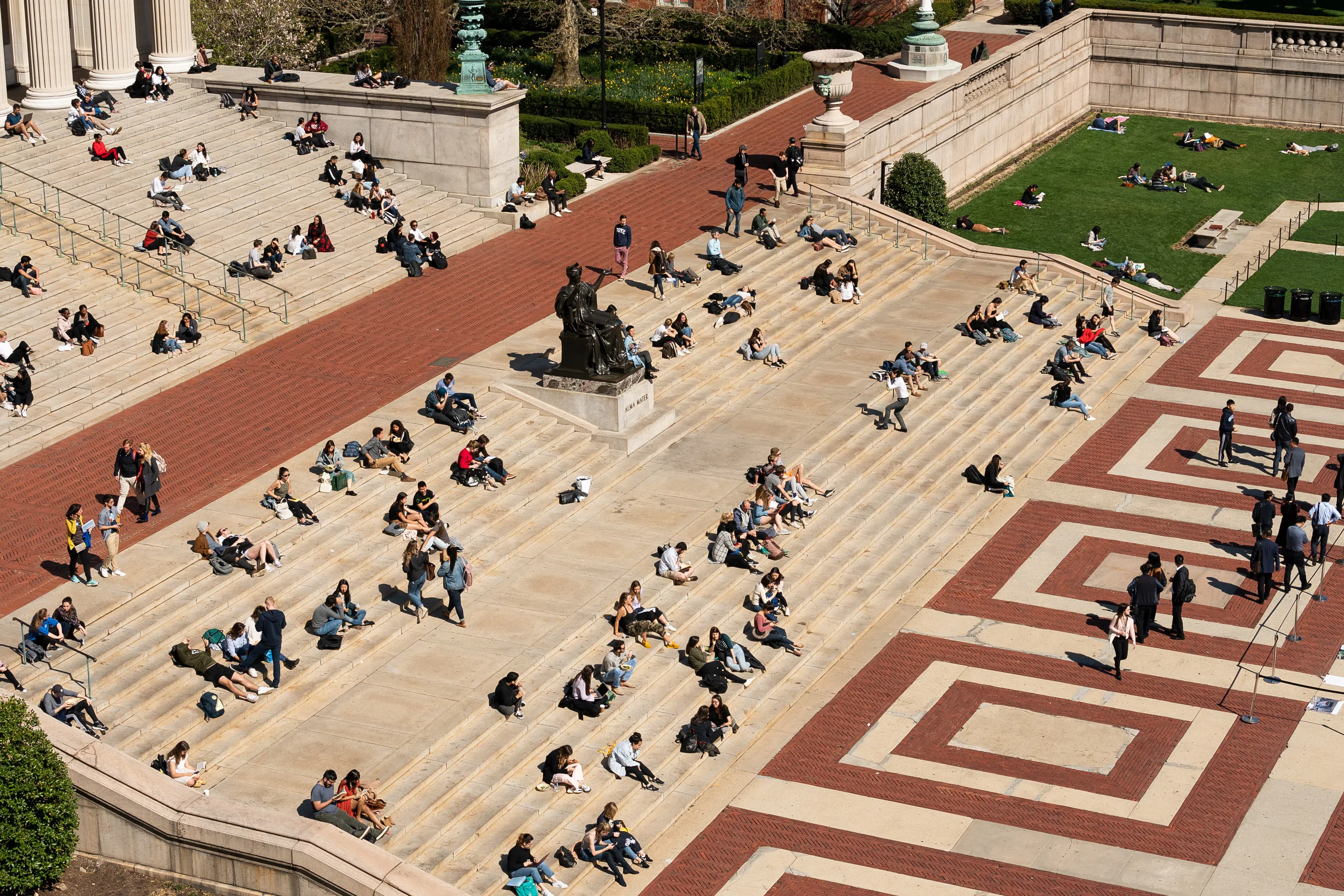 An aerial view of Low steps, dozens of students sit on the steps in the Sun.