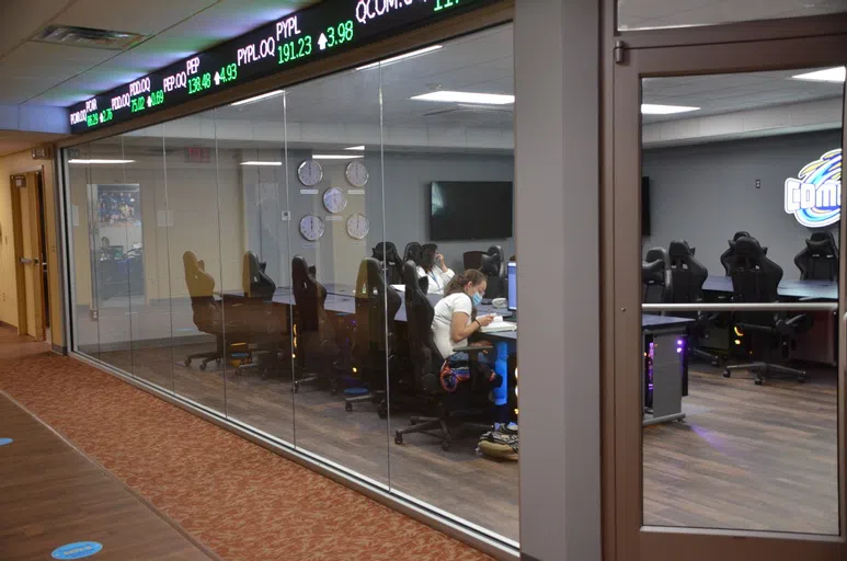 A glass room with a large stock ticker running around the exterior