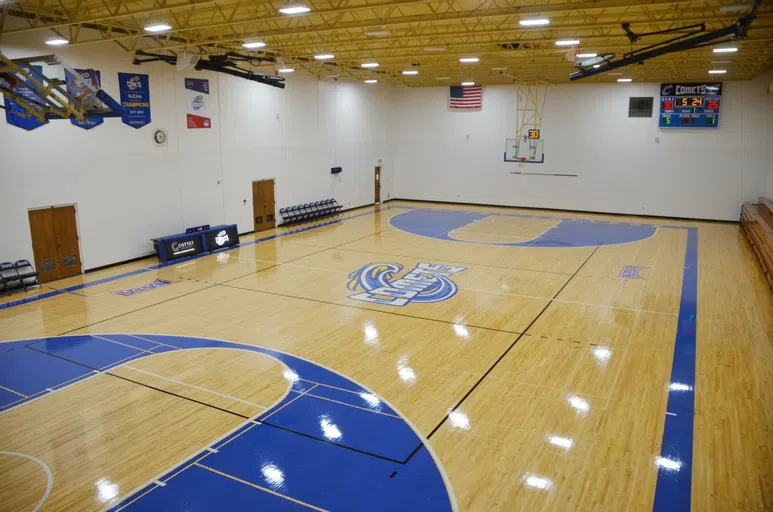 Glossy wooden floor, school colors, and a giant Cottey Comets logo accentuate this basketball court