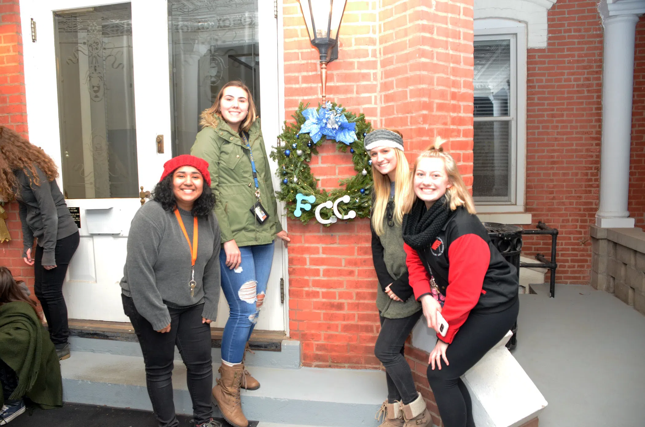 Students hanging a wreath outside one of the residence halls