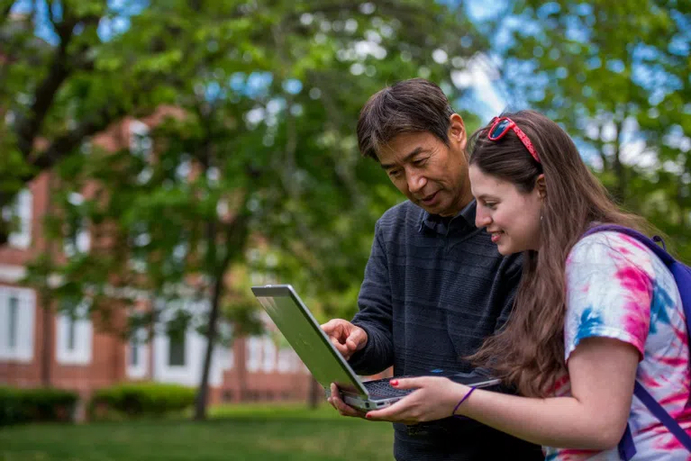 A professor looks at a problem with a student