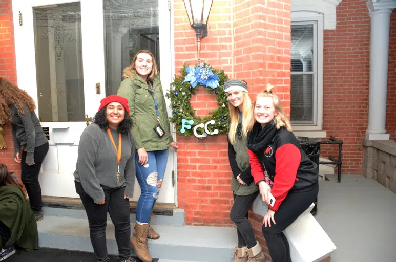 Students hanging a wreath outside one of the residence halls