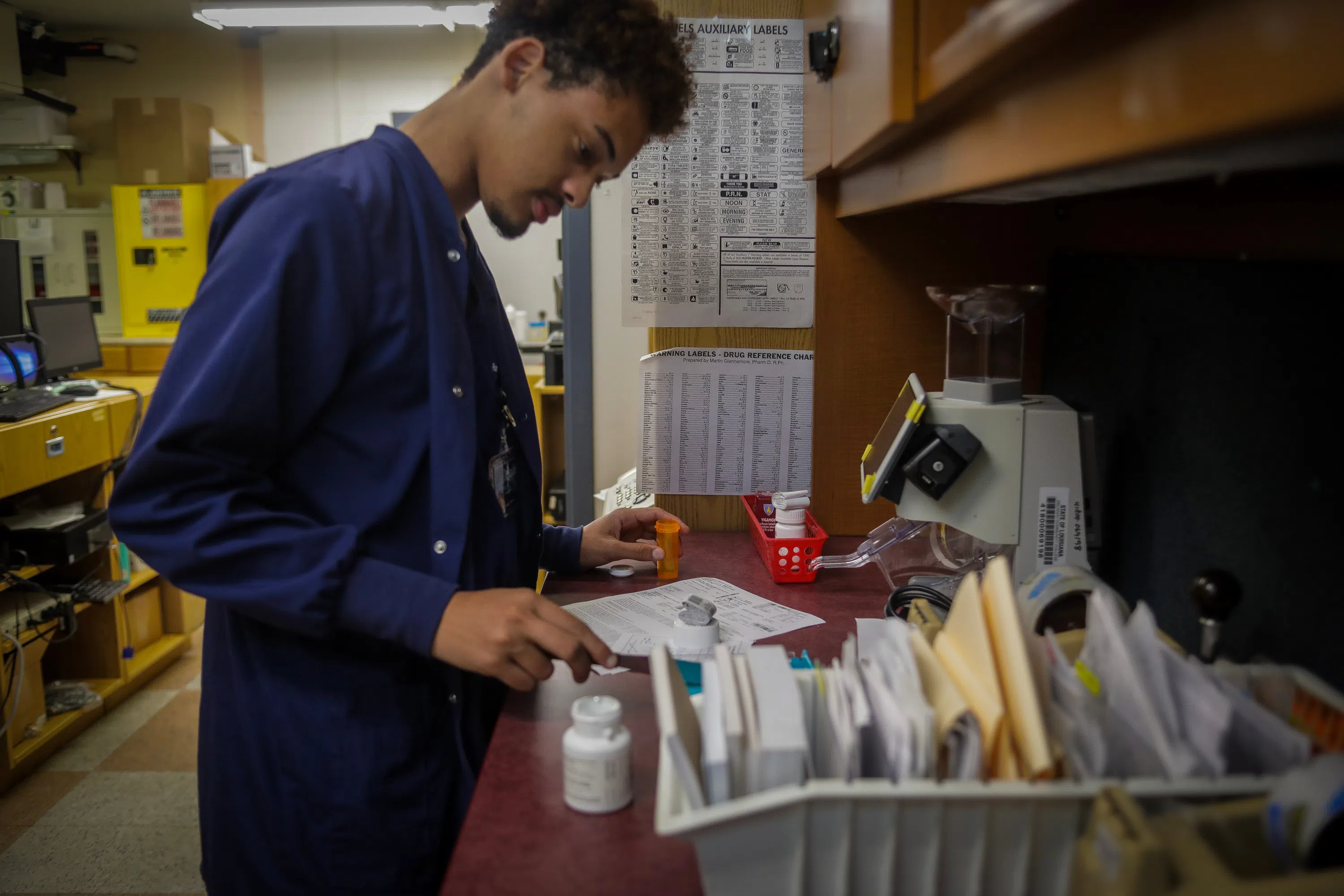 pharmacy student looking through paperwork at counter