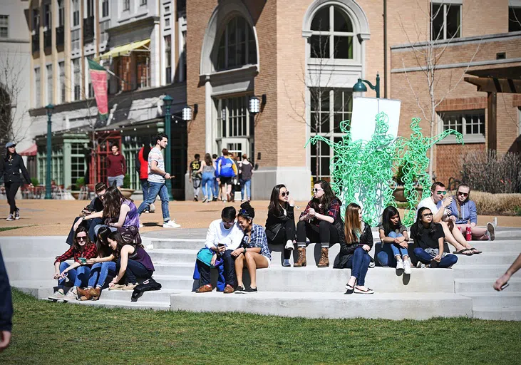 Students sit near the Swamp on the South 40