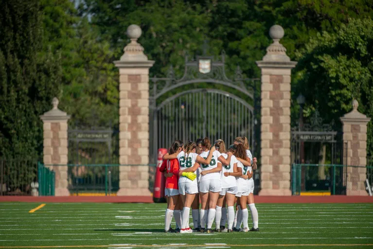 Student athletes huddle on Francis Field