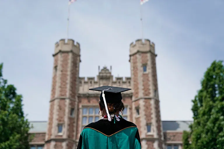 Student looks at Brookings Hall during Commencement