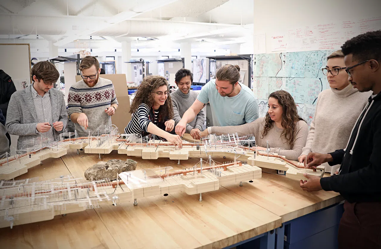 Students gathered around an architectural model