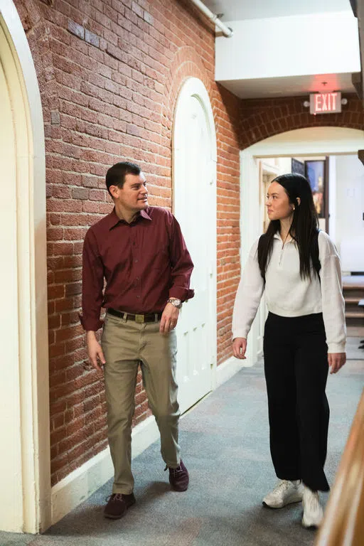 Professor and student walking through hallway