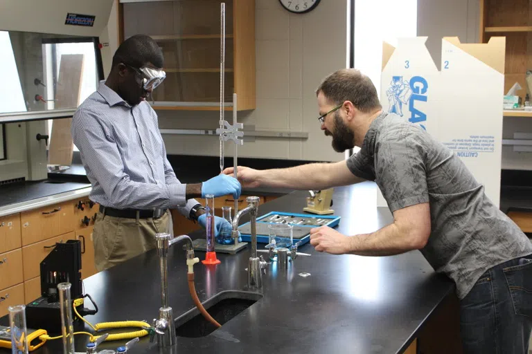 Students testing formulas in chemistry lab.