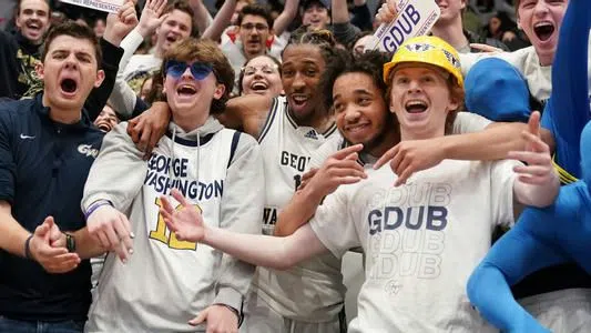 Players on the men's basketball team join the students in the crowd after a big win.