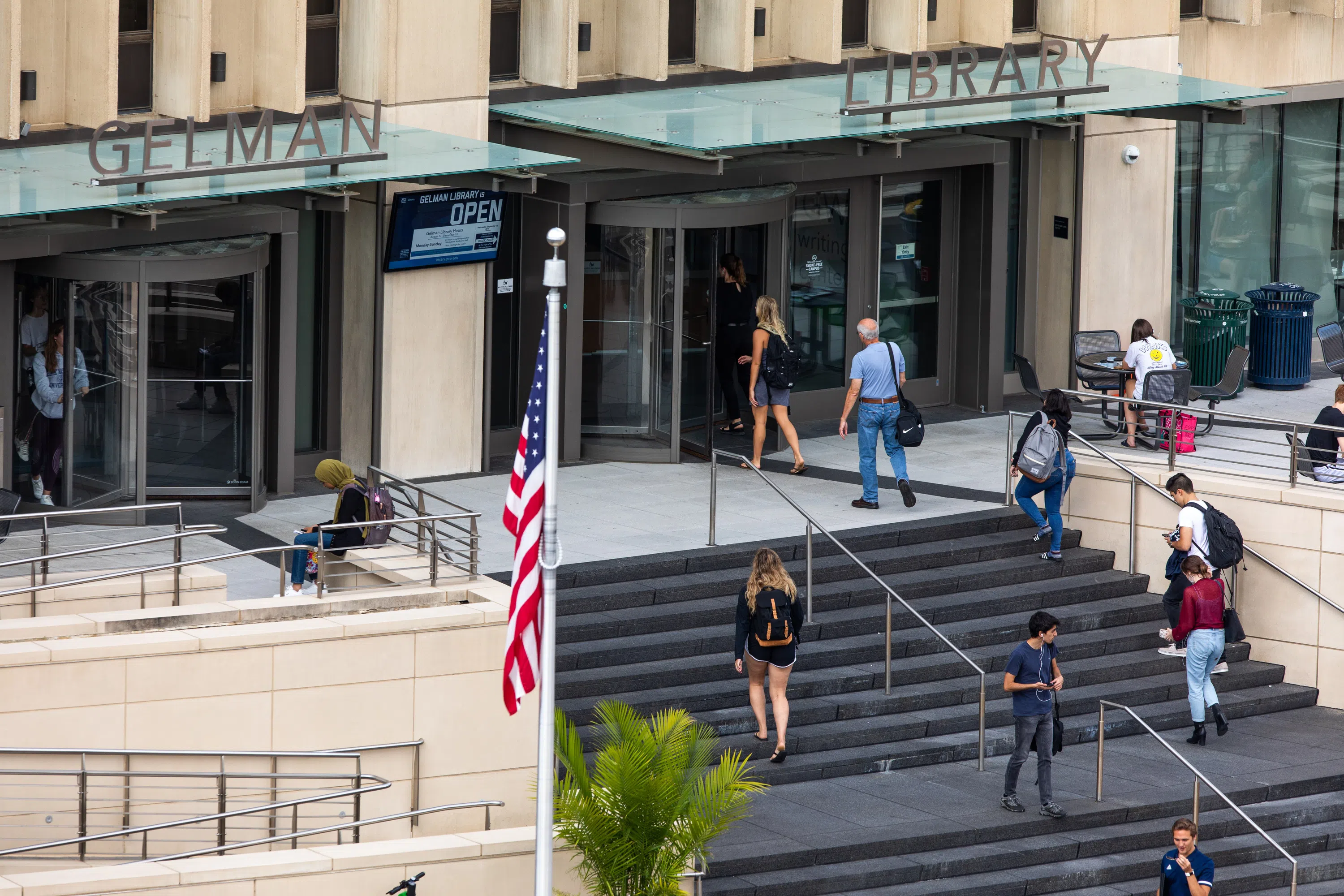 Exterior view of students walking up the entry stairs to the Gelman Library.