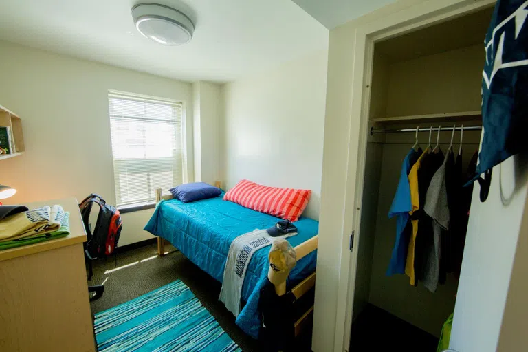 A single room in West Hall includes a bed, desk and chair, and closet