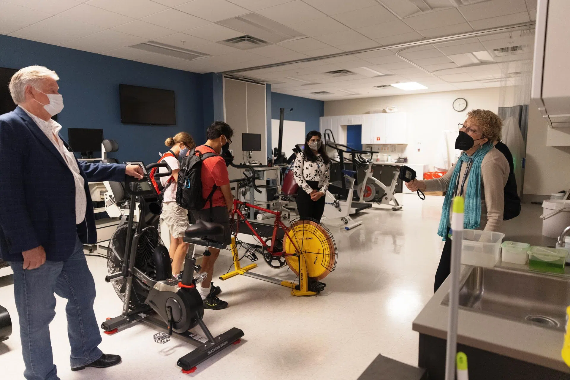 Guests tour a lab in the School of Public Health with exercise bikes and monitoring equipment