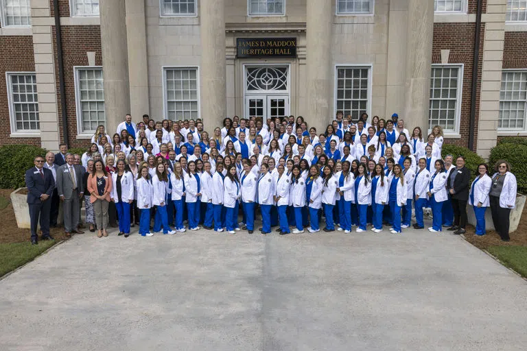 Nursing students pose in front of Heritage Hall