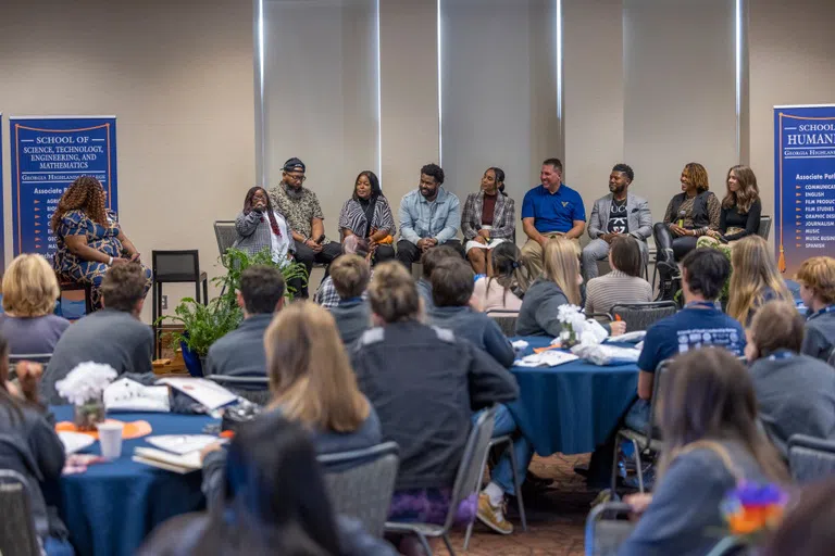 Students seated at round tables attend a School of Science, Technology, Engineering and Mathematics panel in the ballroom. 