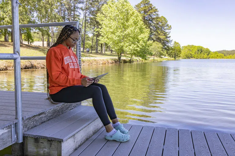 Student studies beside Paris Lake.