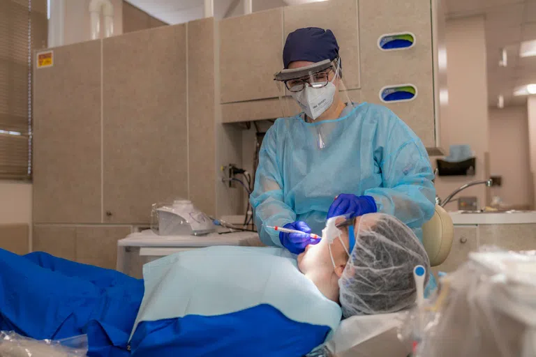 Student examines patient in dental chair