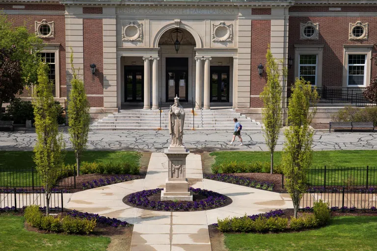 a statue stands in the area in front of the dining hall