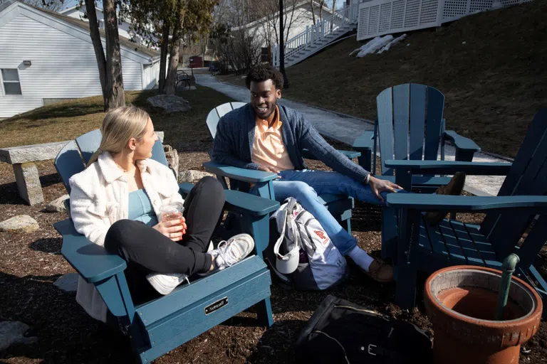 students sit in chairs outside