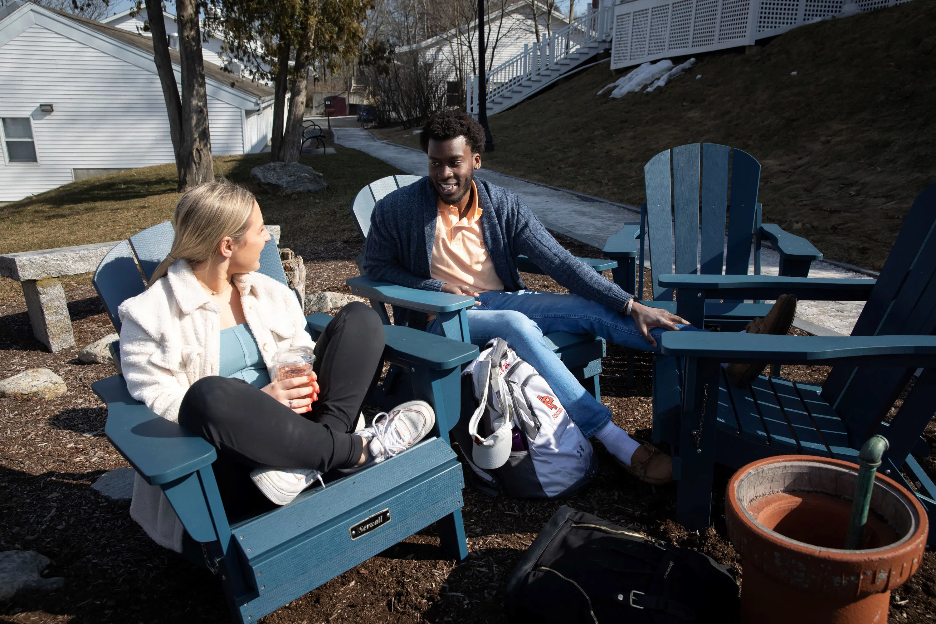 students sit in chairs outside