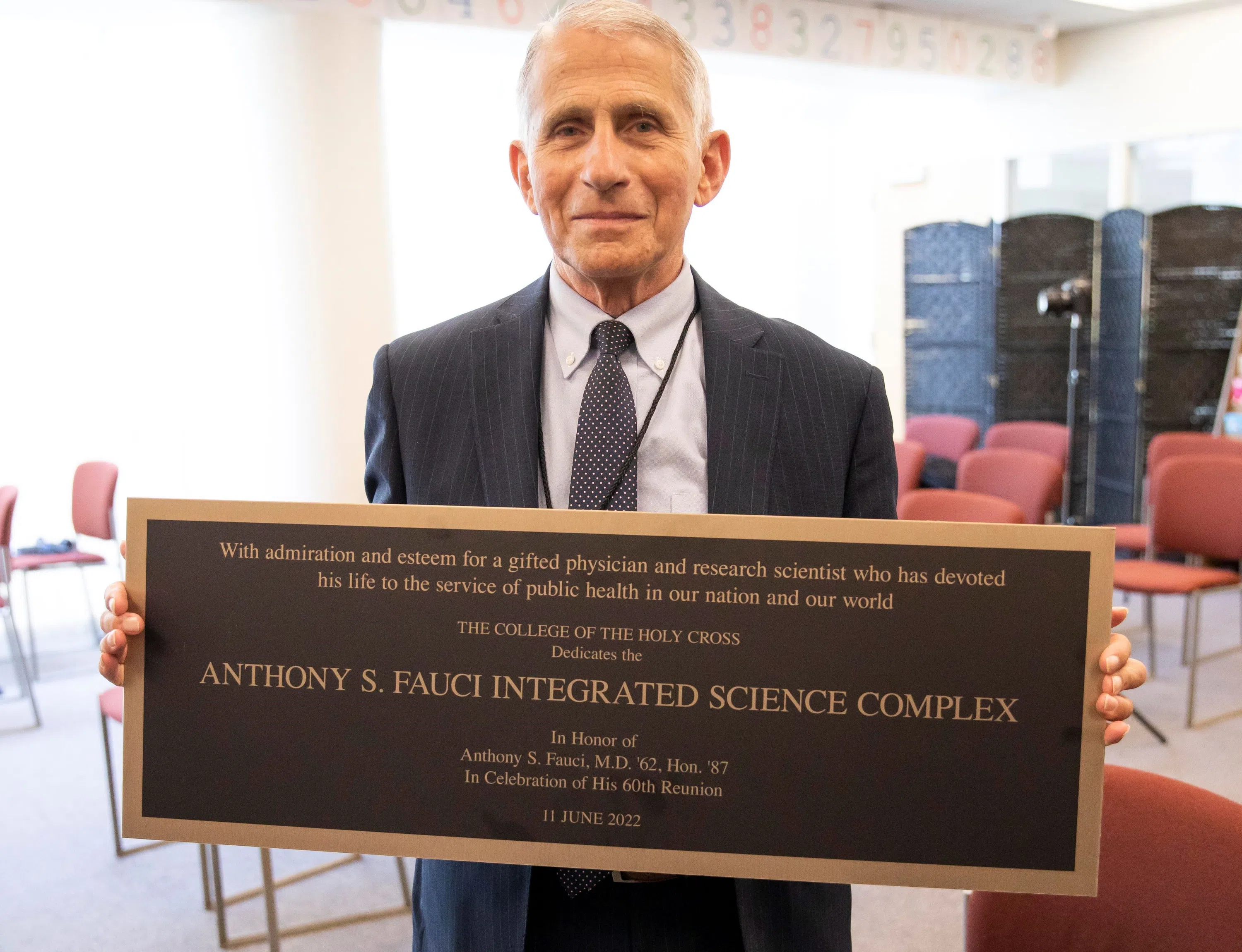 Dr Anthony Fauci holding dedication sign