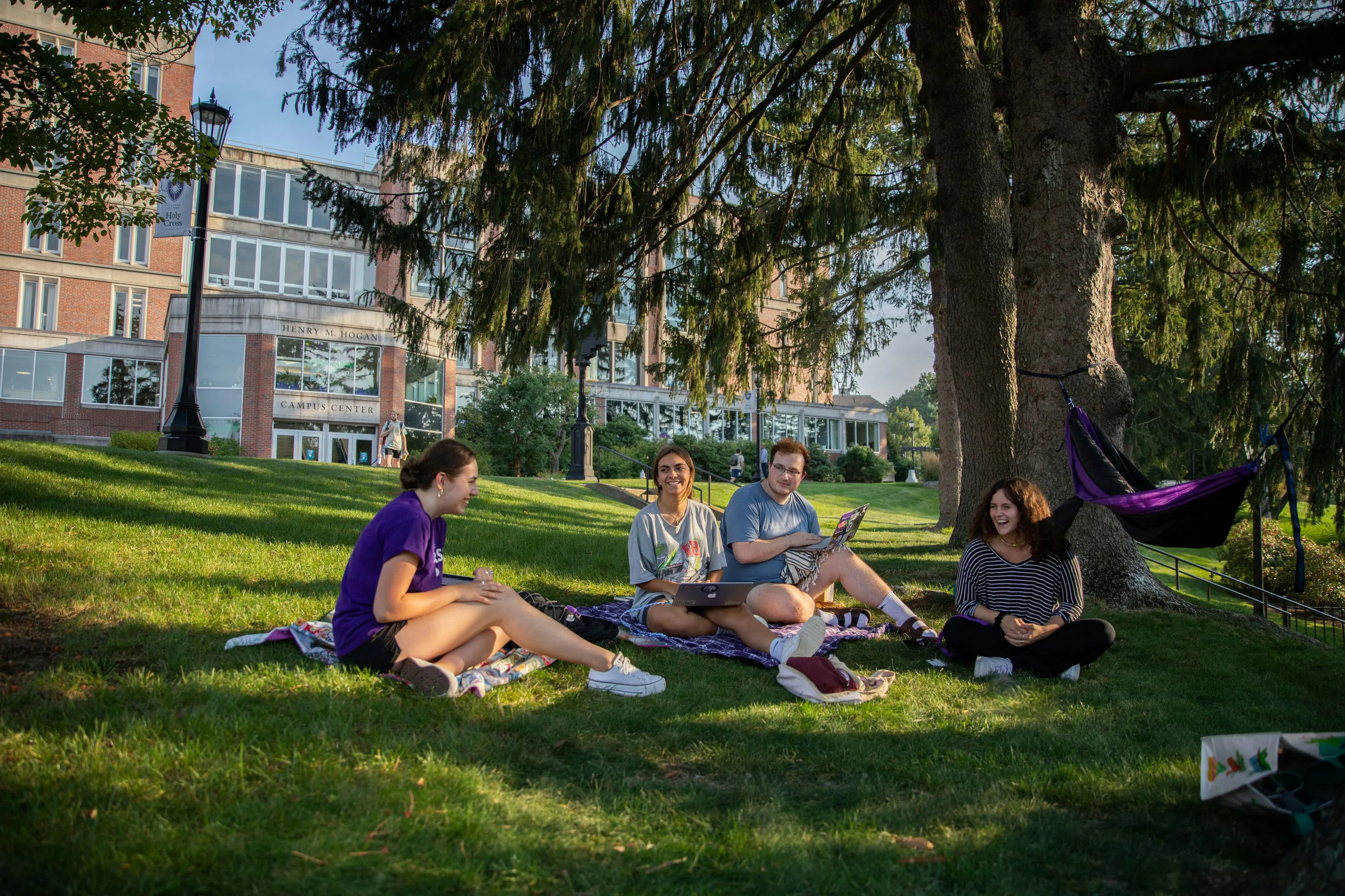 Students studying outside hogan on the grass 
