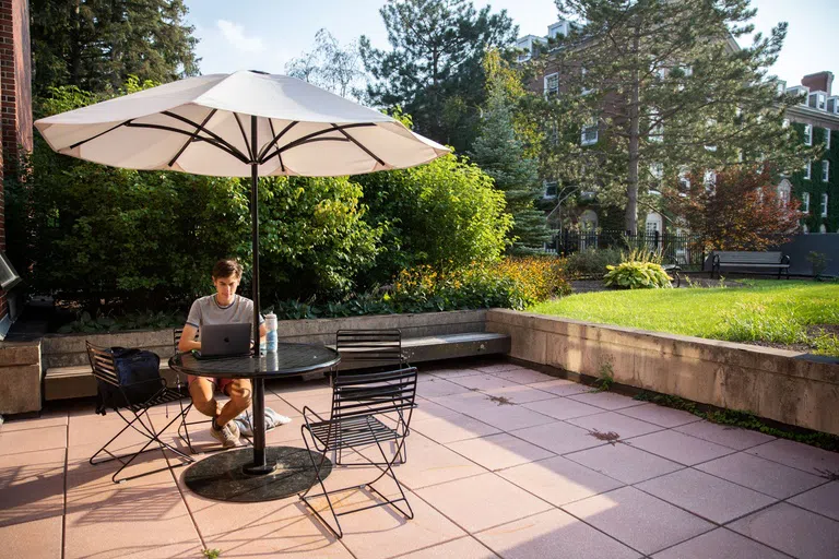 Student studying outside on library patio